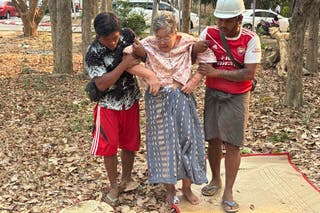 Rescue workers help an injured women who was trapped under a building Friday